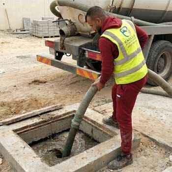 عامل يقوم بشفط بيارة